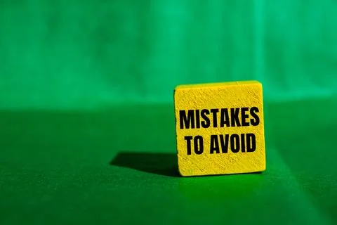 Mistakes to avoid message written on yellow wooden cube with green backgrou.. Foto stock