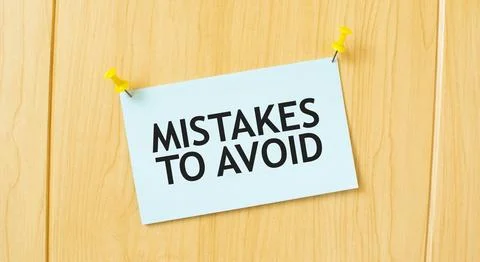 MISTAKES TO AVOID sign written on sticky note pinned on wooden wall 写真素材