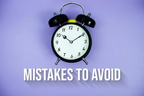 Mistakes To Avoid text and alarm clock on purple background 库存照片