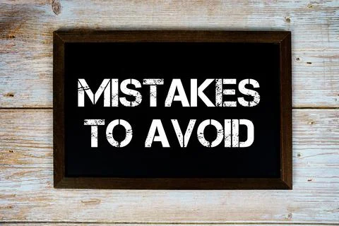 Mistakes To Avoid text with gift box present and alarm clock on black backg.. 库存照片