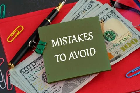 MISTAKES TO AVOID, text on a green sticker on the background of American doll Stock Photos