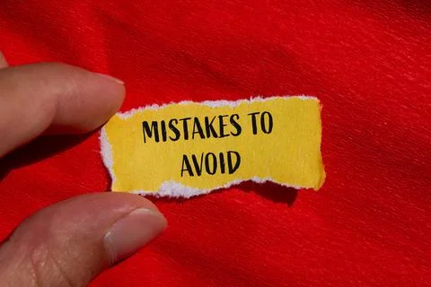 Mistakes to avoid words written on ripped yellow paper with red background. C Stock Photos