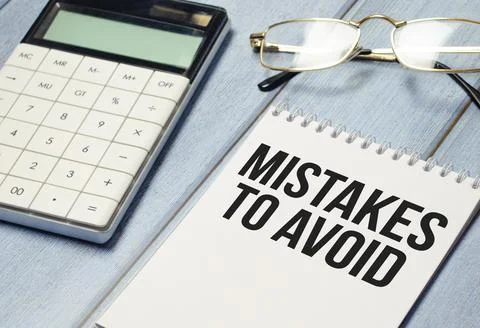 Mistakes to avoid is written in a white notepad near a calculator Stock Photos