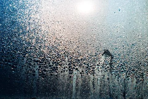 Misted window with drops of moisture that glows in the sun.Texture, template  Stock Photos