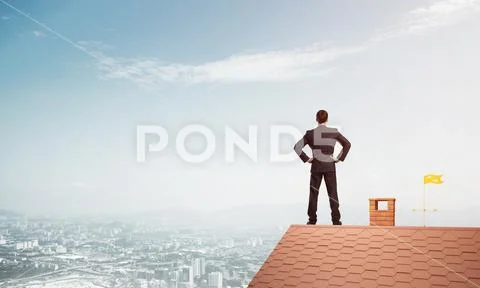 Mister boss on brick roof with arms akimbo. Mixed media Stock Photos