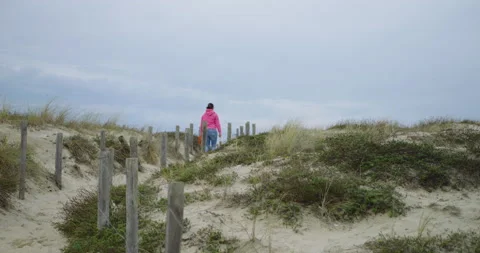 Mistress walking a path in the dunes with her dog Stock Footage 230031749
