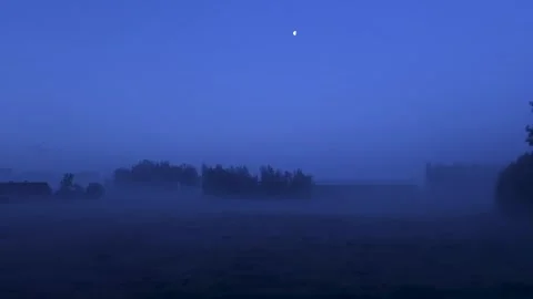Misty blue dusk over field with moon Stock Footage 337800411