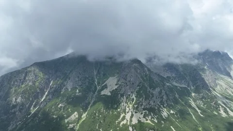 Misty clouds covering a rugged alpine mountain ridge Stock Footage 345168698