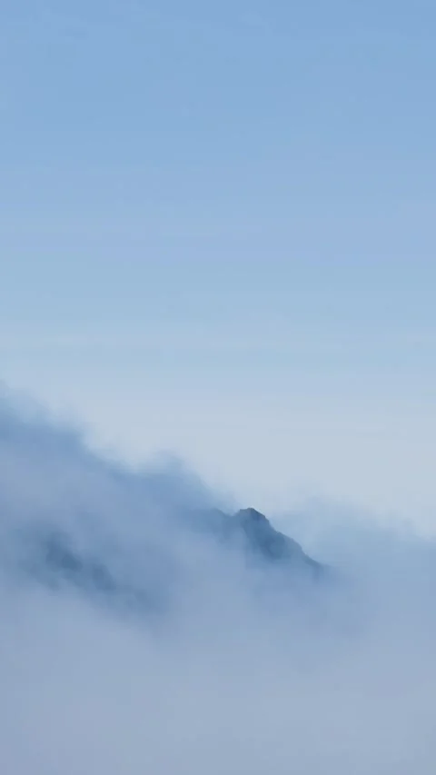 Misty clouds flowing over a serene mountain peak Stock Footage 334443899