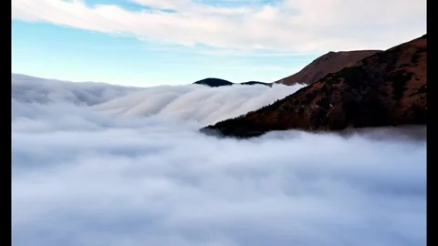Misty Clouds Flowing Like Waterfalls in Alpine Mountains Stock-Footage 295763681