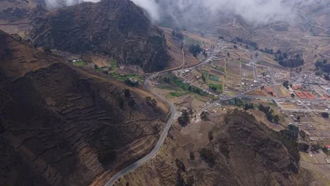 Misty clouds hovering above Ecuadorian Andes, revealing serpentine mountain road Stock Footage 308398848