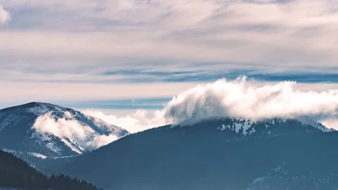 Misty clouds motion snowy mountains ridge in sunny winter alps nature time lapse Stock Footage 168531695