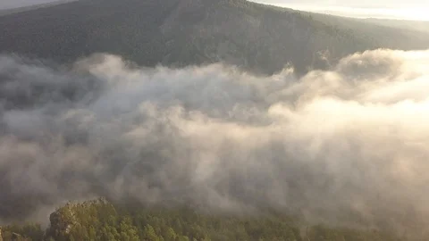 Misty clouds over river valley in mountains Video stock 93728644