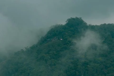 Misty clouds passing on top of the mountains or hills. Greenery mountains o.. Stock Photos