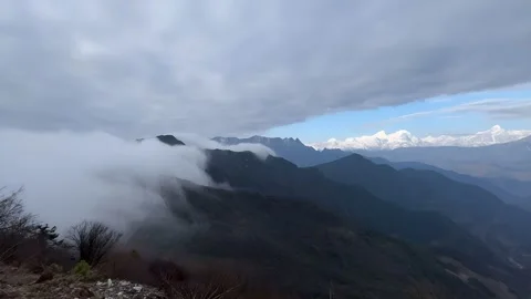 Misty Clouds Rolling Over Lush Green Mountains with Distant Snow Peaks, Sichuan Stock-Footage 337379014