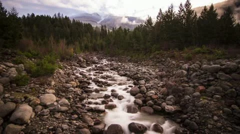 Misty Clouds on a Snowy Mountain Top and River Running Video stock 12681219