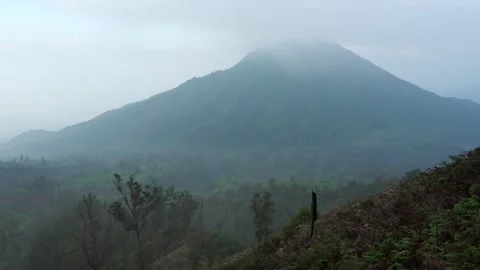 Misty, cloudy landscape view of Ijen slope Volcano in East Java, Indonesia Stock Footage 312426457