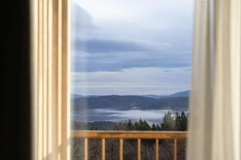A misty forest landscape seen through a glass window from inside a cozy room, Stock Photos