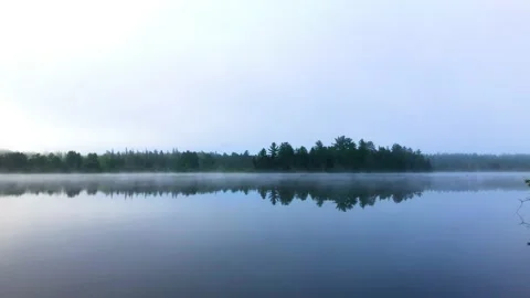 Misty lake with mirror reflections on a cool summer morning Stock Footage 225301807