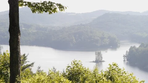 Misty lake is shot from an elevated viewpoint Stock Footage 99117327