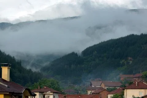 Misty landscape - view over the rooftops of the village. Stock Photos