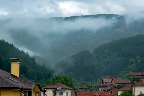 Misty landscape - view over the rooftops of the village. Stock Photos