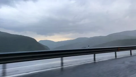 Misty mountain highway view with cloudy sky and metal railing Stock Footage 310246374