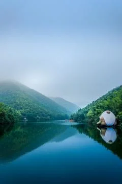 Misty mountain lake with forest reflection Stock Photos