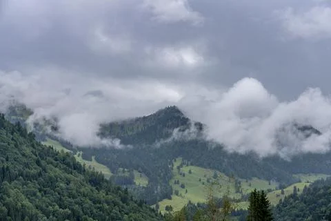 Misty Mountain Landscape: Clouds Rolling Over Green Peaks Stock Photos