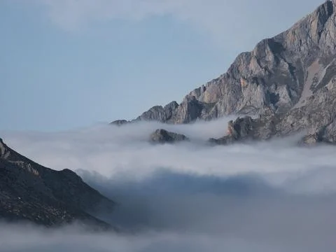 Misty mountain peaks emerging from clouds - Close-up of rocky mountain slop.. Stock Photos