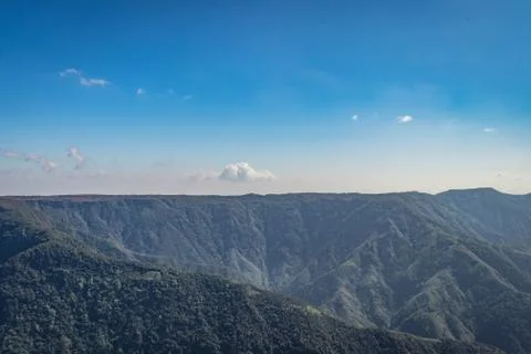 Misty mountain range covered with white mist and amazing blue sky 库存照片