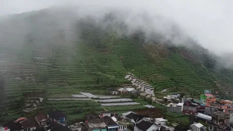 Misty Mountain with Terraced Fields and Village in Dieng Plateau, Indonesia Stock Footage 280018230