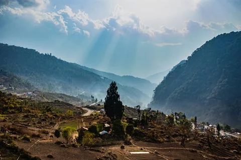 Misty mountain valley with sun rays beams at morning from flat angle Фото