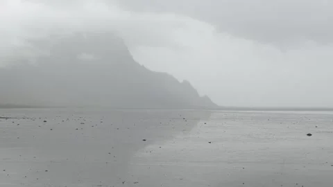 Misty mountains reflecting in shallow tidal water in Iceland 4K nature footage Video stock 339927178