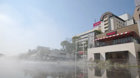 Misty pool of water in front of TGI Friday's restaurant in Nagoya, Japan. Stock Footage 217284774