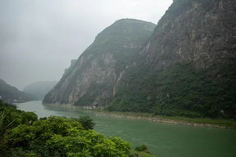 Misty river winds through steep green cliffs Photos