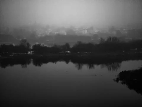 Misty riverscape with town reflection Fotos de archivo