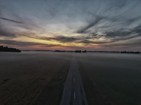 Misty road to sunset Stock Photos