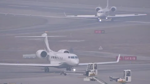 Misty scene two white gulfstream business jets positioned different distances Stock Footage 328122594