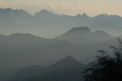 Misty sunset with beautiful silhouette of mountain range in Switzerland Stock Photos