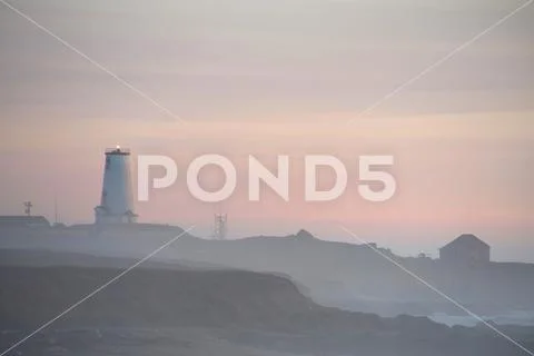 Misty sunset at Piadras Blancas Lighthouse along the coast in Northern Califo Stock Photos