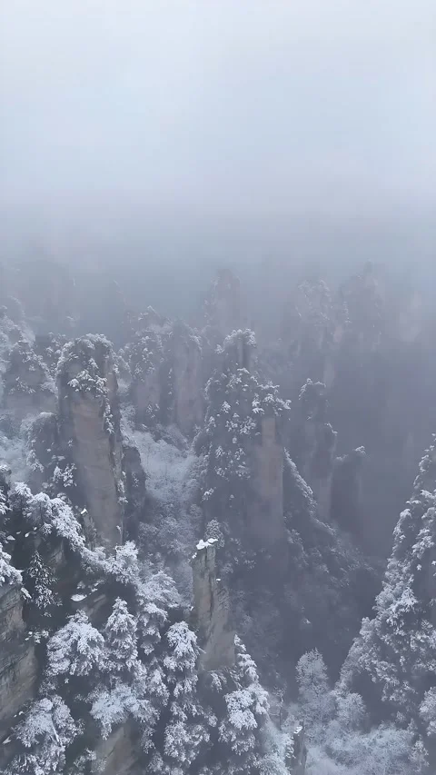 Misty Winter Landscape of Snow-Covered Quartz Sandstone Pillars Zhangjiajie Stock Footage 345727482