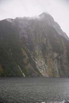 Mitre Peak coming out of the clouds. Stock Photos