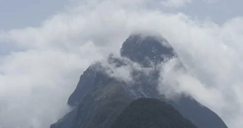 Mitre Peak engulfed in clouds on a sunny day in Milford Sound New Zealand Stock Footage 120321572