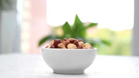 A mix of assorted nuts in a bowl is spinning on the table.  Stock Footage 161296020