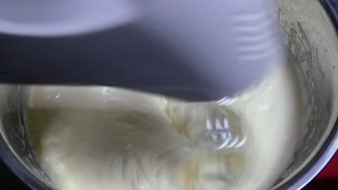 Mix the cake batter using a mixer from the eggs, flour and sugar Stock Footage 306759670