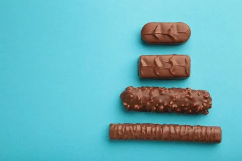 Mix of chocolate bars on blue background. Top view. Stock Photos