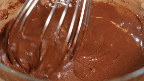 Mix the chocolate mixture with a kitchen whisk. making a chocolate cake. Stock Footage 111635458