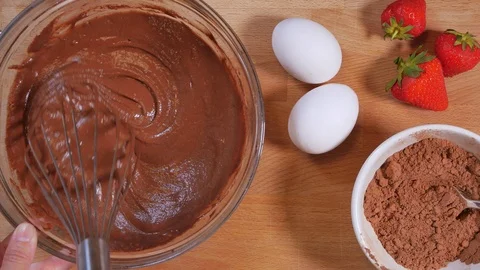 Mix the chocolate mixture with a kitchen whisk. making a chocolate cake. strawbe Stock Footage 111637010