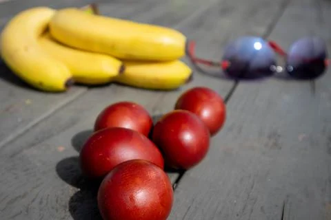 Mix composition with painted easter eggs, bunch of ripe bananas and sunglasses Stock Photos